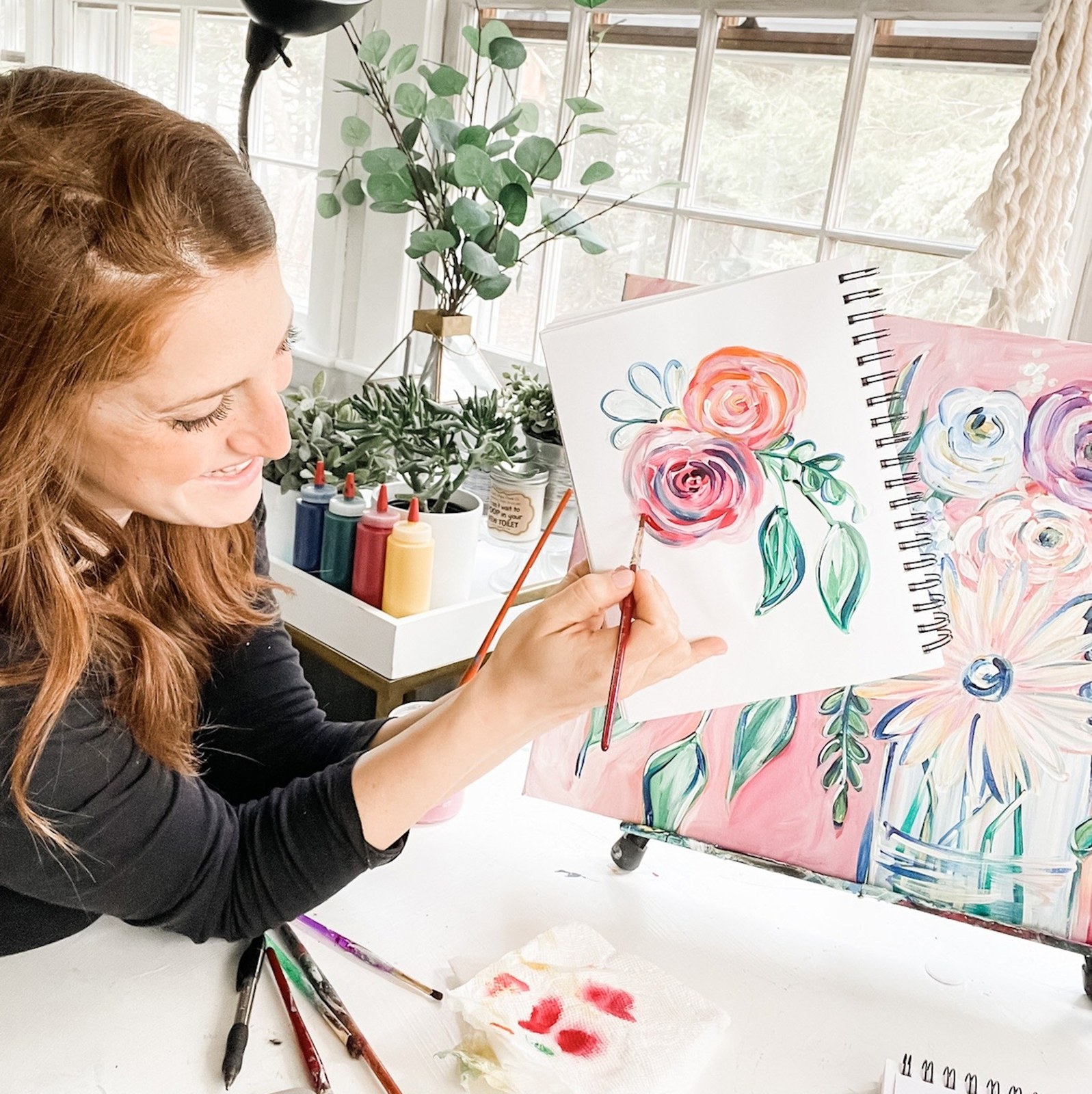 Jackie painting at her easel in the studio